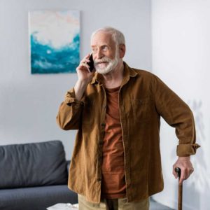 an elderly man with a cane on the phone