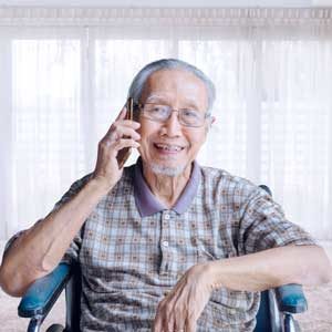 Old man talking with cellphone on wheelchair