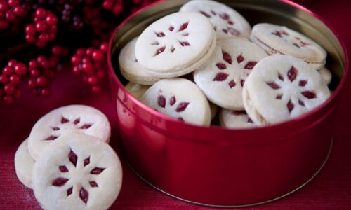 a tin full of small white and red cookies