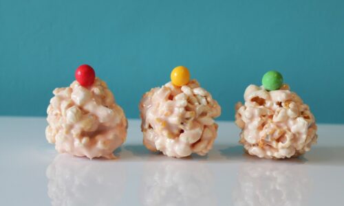 three popcorn balls with candies on top